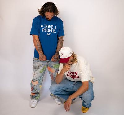 Two people wearing 'Love People' t-shirts on a white background