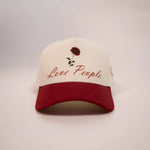Cap with red rose design and 'Love People' text on a white background