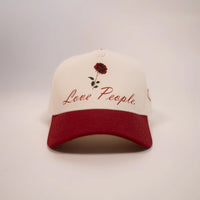 Cap with red rose design and 'Love People' text on a white background