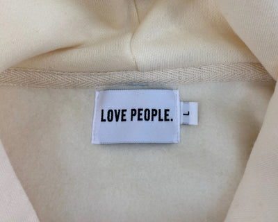 Label with 'LOVE PEOPLE.' text on a beige fabric background